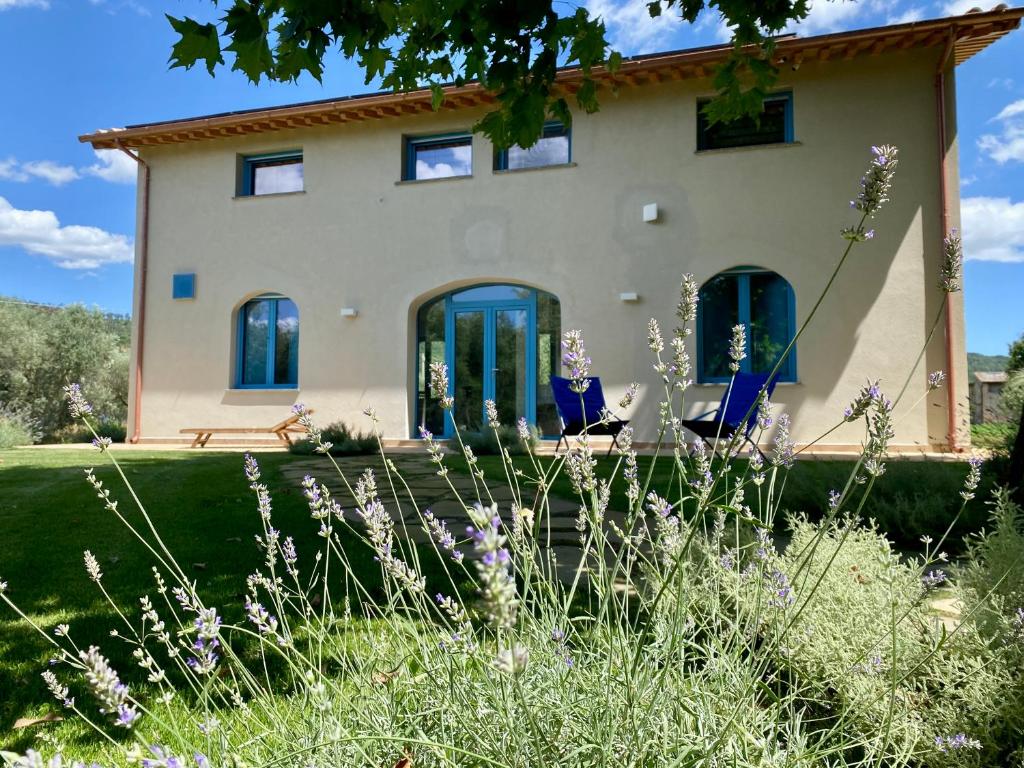 a house with two blue chairs in front of it at La Traversa Di Bolsena in Bolsena