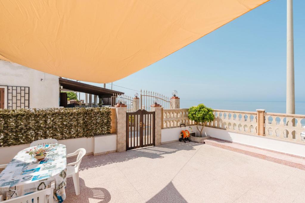 un patio con una valla y vistas al océano en Casa Damari-Fronte spiaggia, en Petrosino