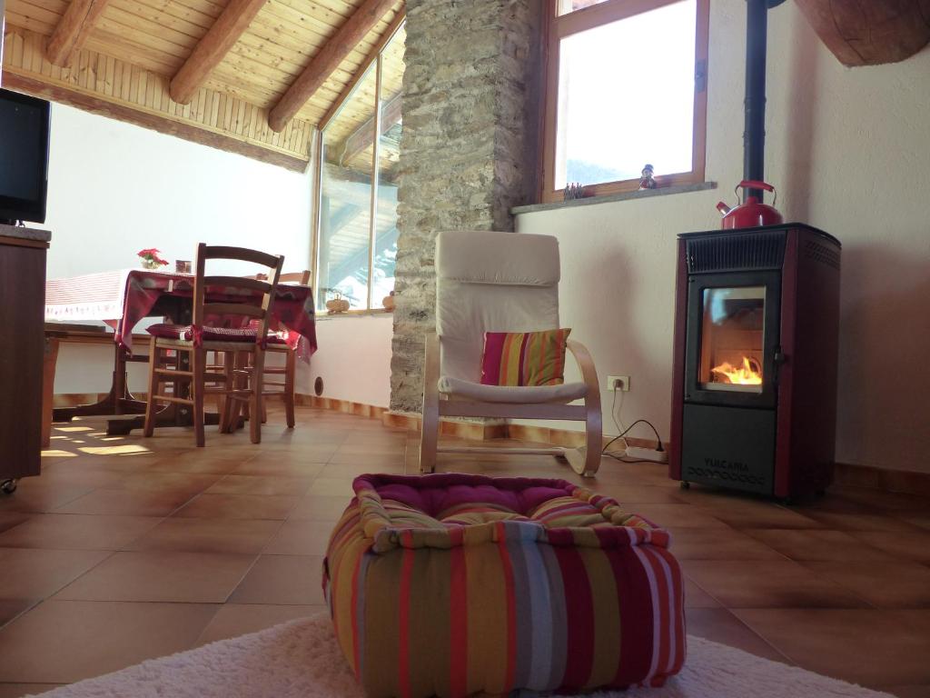 a living room with a wood stove and a chair at Appartamenti Grivola in Ozein