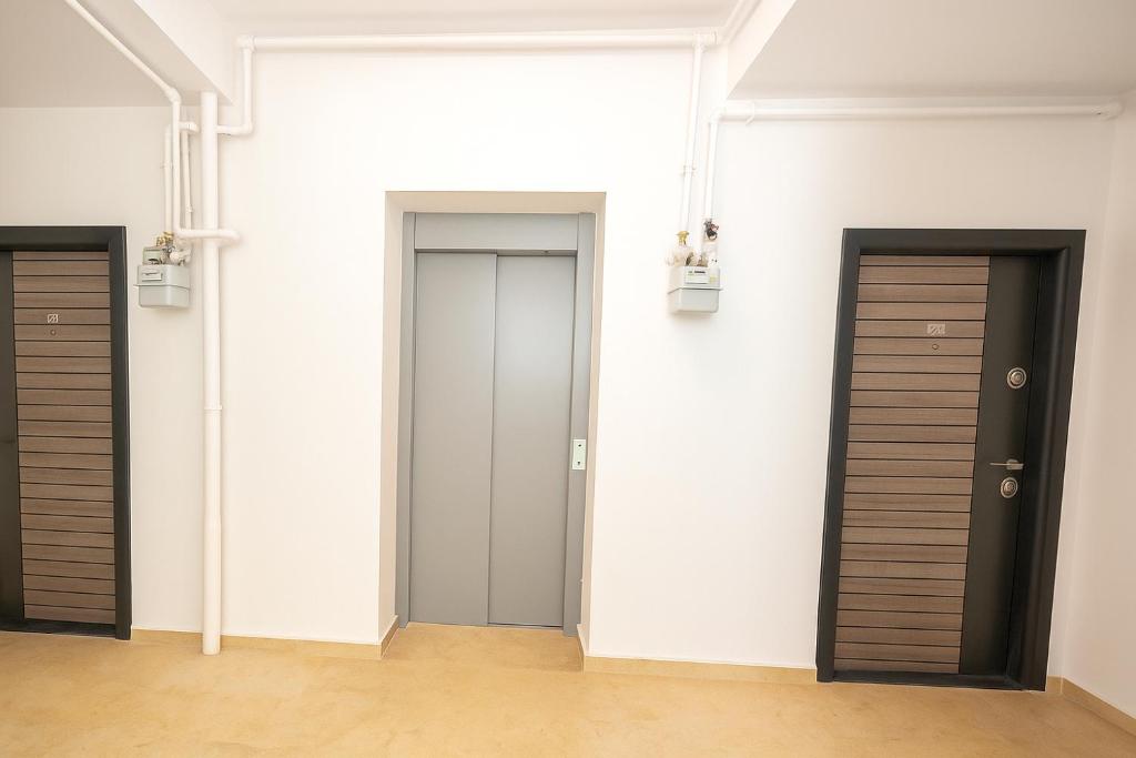 two doors in a room with white walls and wooden floors at Blue Feelings Studio in Mamaia Nord