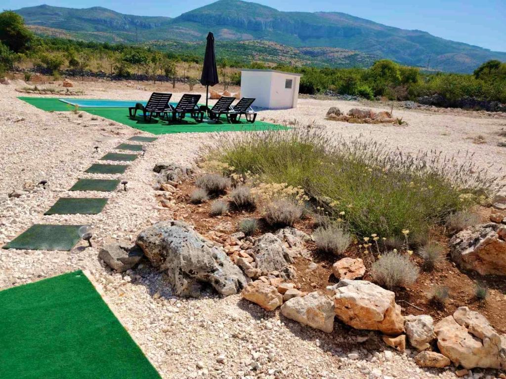 a landscaping with chairs and a green lawn at Prominska Bajka in Razvođe