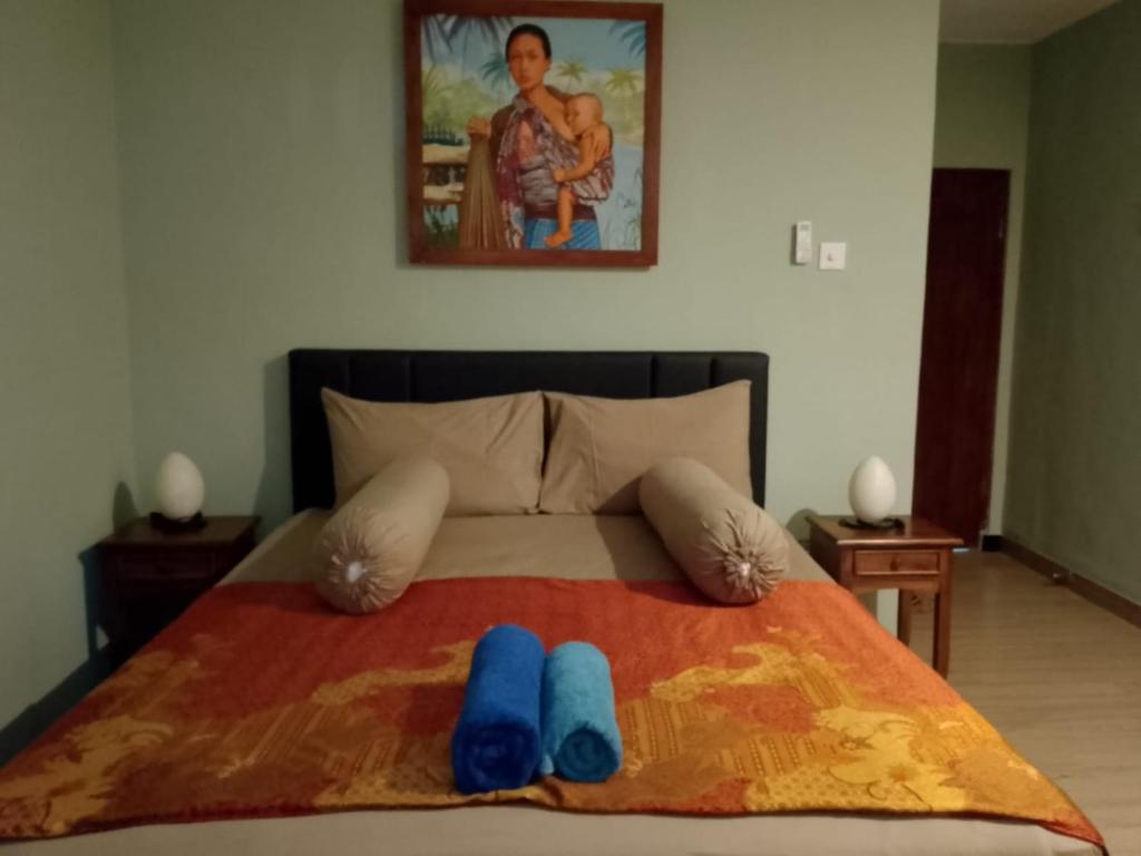 - un lit avec 2 chaussons bleus au-dessus dans l'établissement Ellenbrook Rooms 18 by Mulia Cottage, à Seminyak