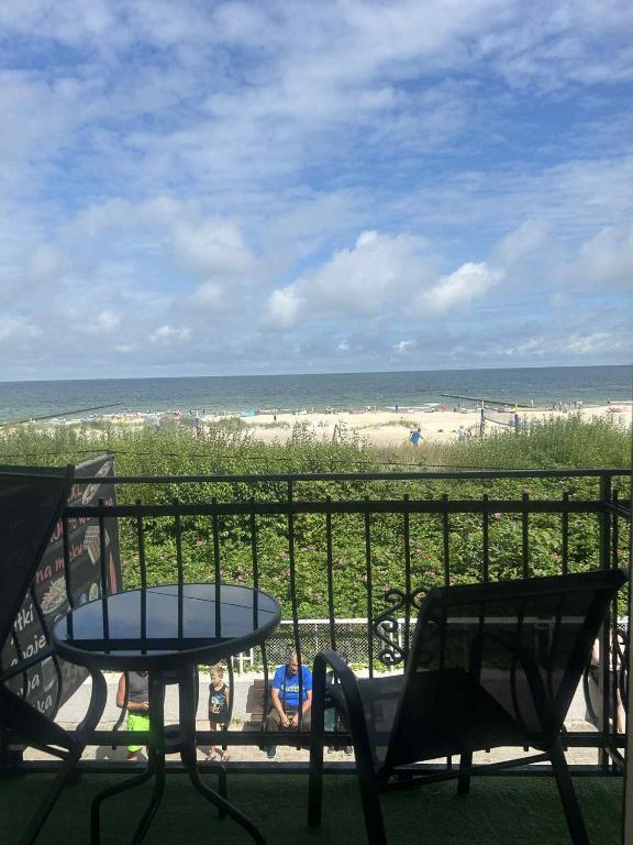 a balcony with a table and chairs and the beach at Zajazd Dajana in Ustka
