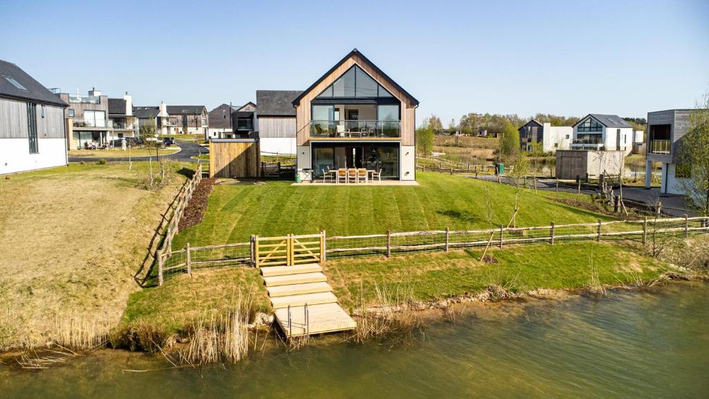a house on a small island in the water at The Lark Ascending BR11 Silverlake Dorset in Warmwell