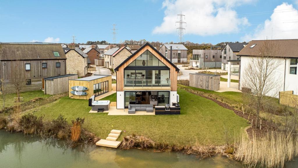 une maison située au sommet d'un champ à côté d'un plan d'eau dans l'établissement Robins Retreat Silverlake OI19 Silverlake Dorset, à Warmwell