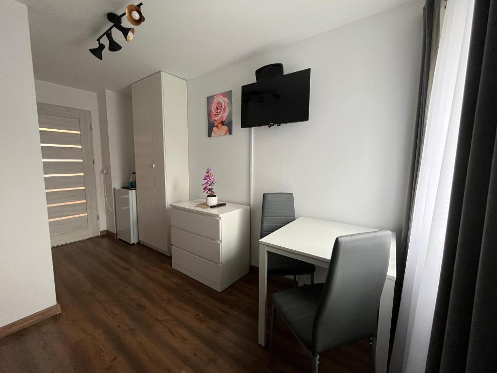 a small white room with a table and a chair at Przystanek Zator in Zator