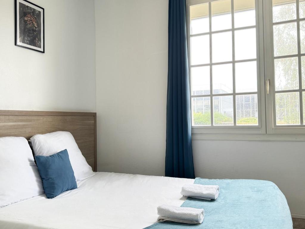 une chambre avec un lit avec deux serviettes dessus dans l'établissement Studio Platanes 5 - Proche Disneyland - Parking gratuit - Meaux, à Meaux