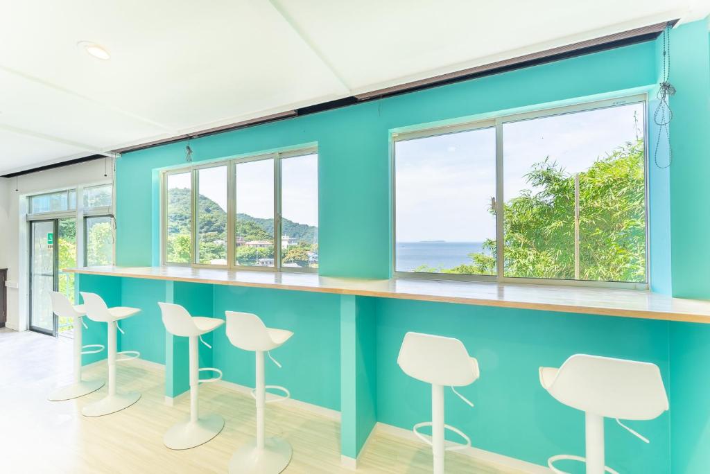 een wachtkamer met blauwe muren en witte krukken bij Villa FUN Kawana in Ito