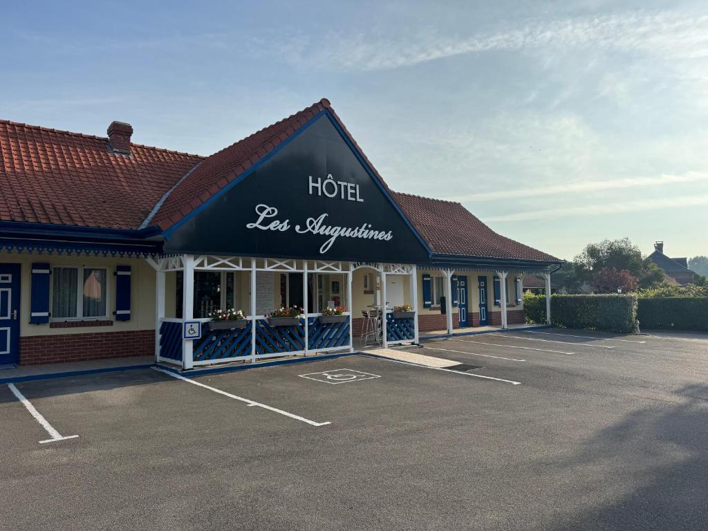 un parking d'hôtel devant un hôtel dans l'établissement Les Augustines, à Quend