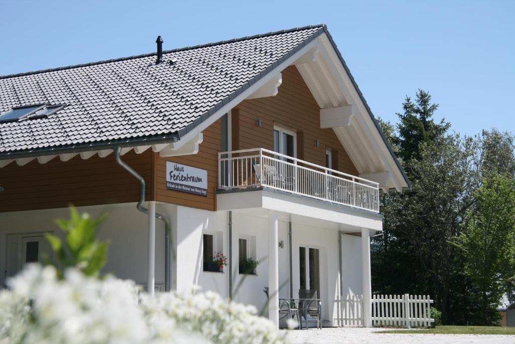 a large wooden house with a balcony at Haus Ferientraum in Feldberg