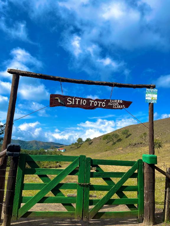 a sign on a gate next to a green fence at Sítio das montanhas in Cunha