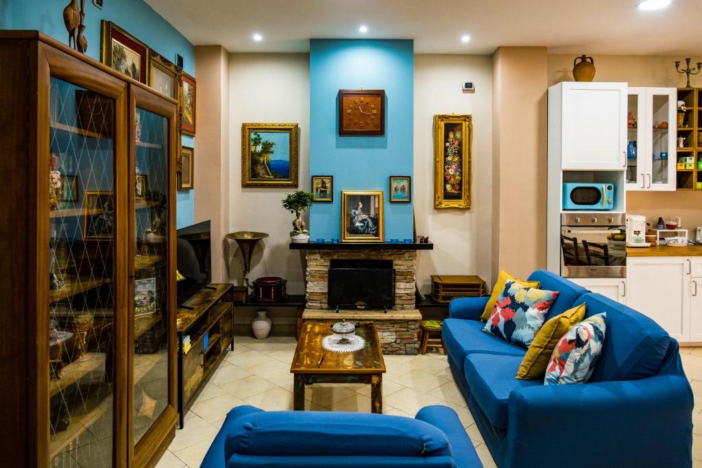 a living room with a blue couch and a fireplace at Luc's Home in Frattaminore