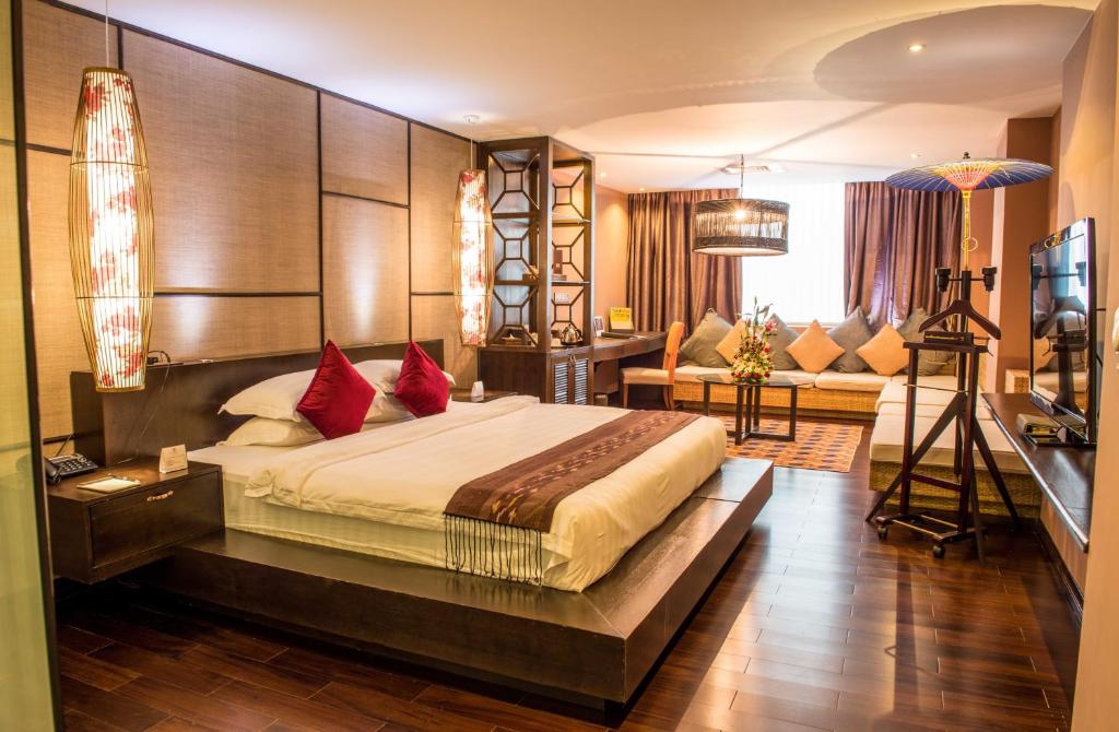 a bedroom with a large bed in a room at Rose Garden Hotel in Yangon