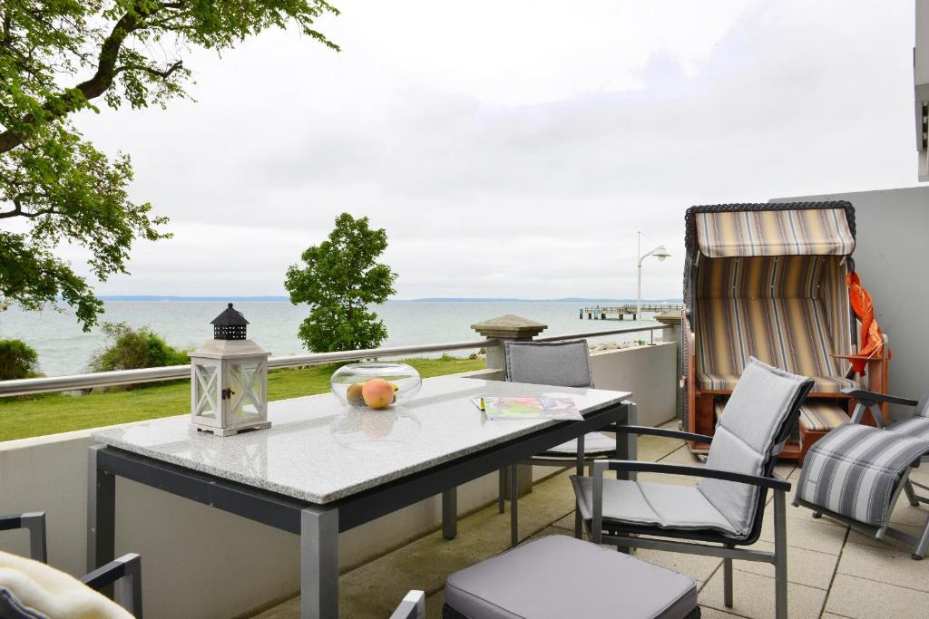 una mesa y sillas en un balcón con vistas al océano en Ferienwohnung Silbermöwe en Sassnitz