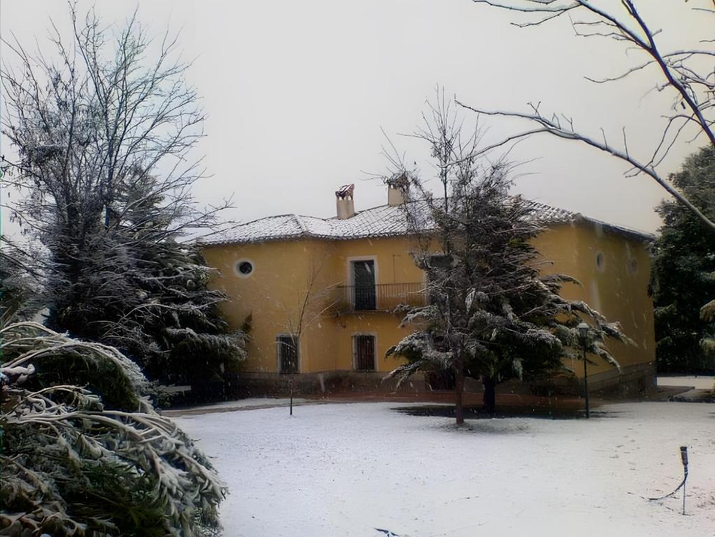 a yellow house with snow on the ground at Ecoagroturismo Las Nieves in Murcia