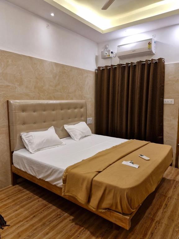 a bedroom with a large bed with white sheets at Saraa Grand in Kuttālam