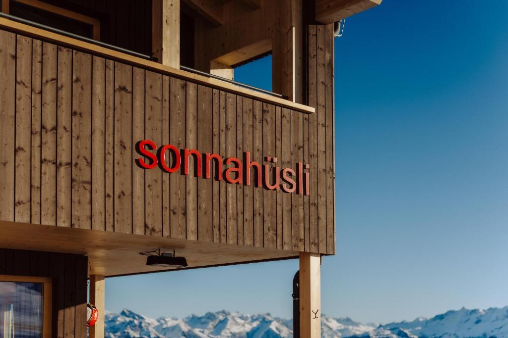 a sign on the side of a building with mountains in the background at Sonna Hüsli Lodge in Tschagguns