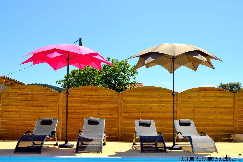 a group of chairs and umbrellas next to a fence at L'escapade provencale in Martigues