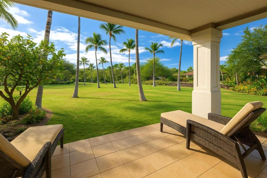 un porche con 2 sillas y césped con palmeras en KBM Resorts 4-Bedroom Islands at Mauna Lani Collection Multi-Unit Listing Steps from One Another Garden Views 2 Free Rental Cars IML-D3E4, en Waikoloa