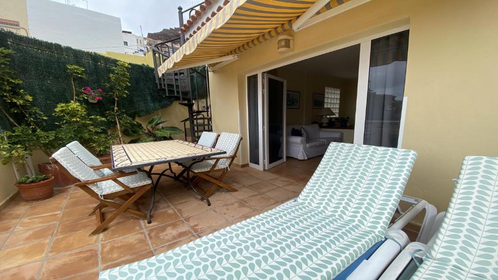 a patio with a table and chairs on a balcony at La Molina Casa in Calera