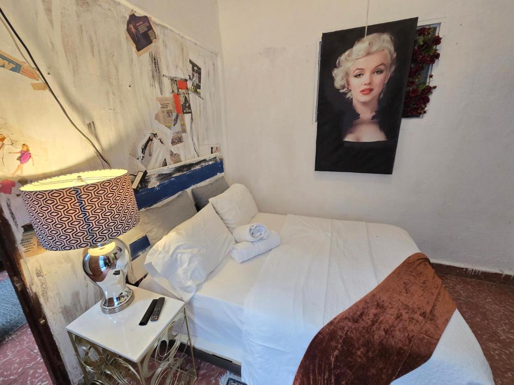 a bedroom with a bed and a picture of a woman at Colonial apartment for up to 4 person in Santo Domingo