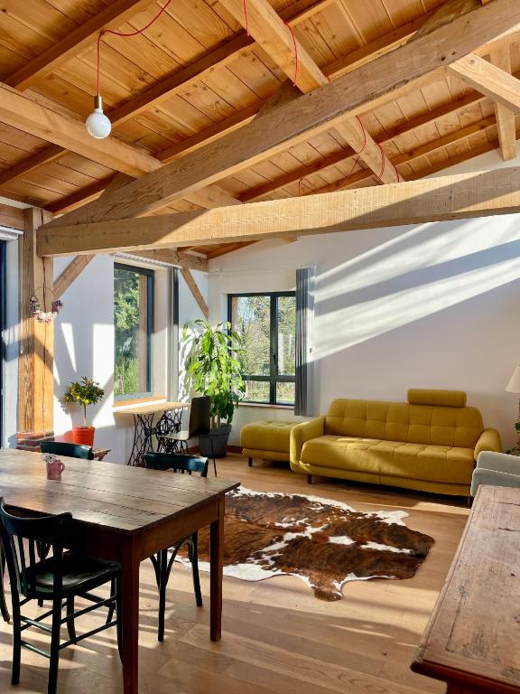 a living room with a table and a couch at Gîte de groupe et charmant cottage L'Agnel in Domaize