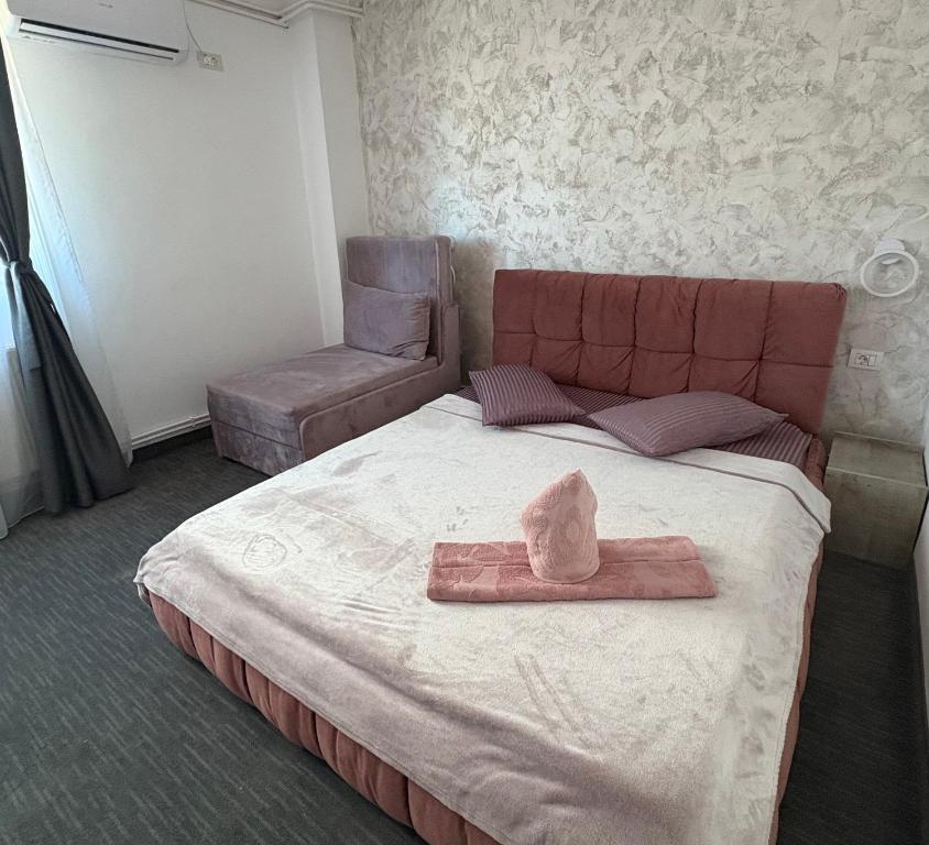 a bedroom with a bed with a towel on it at Hotel AmA in Constanţa