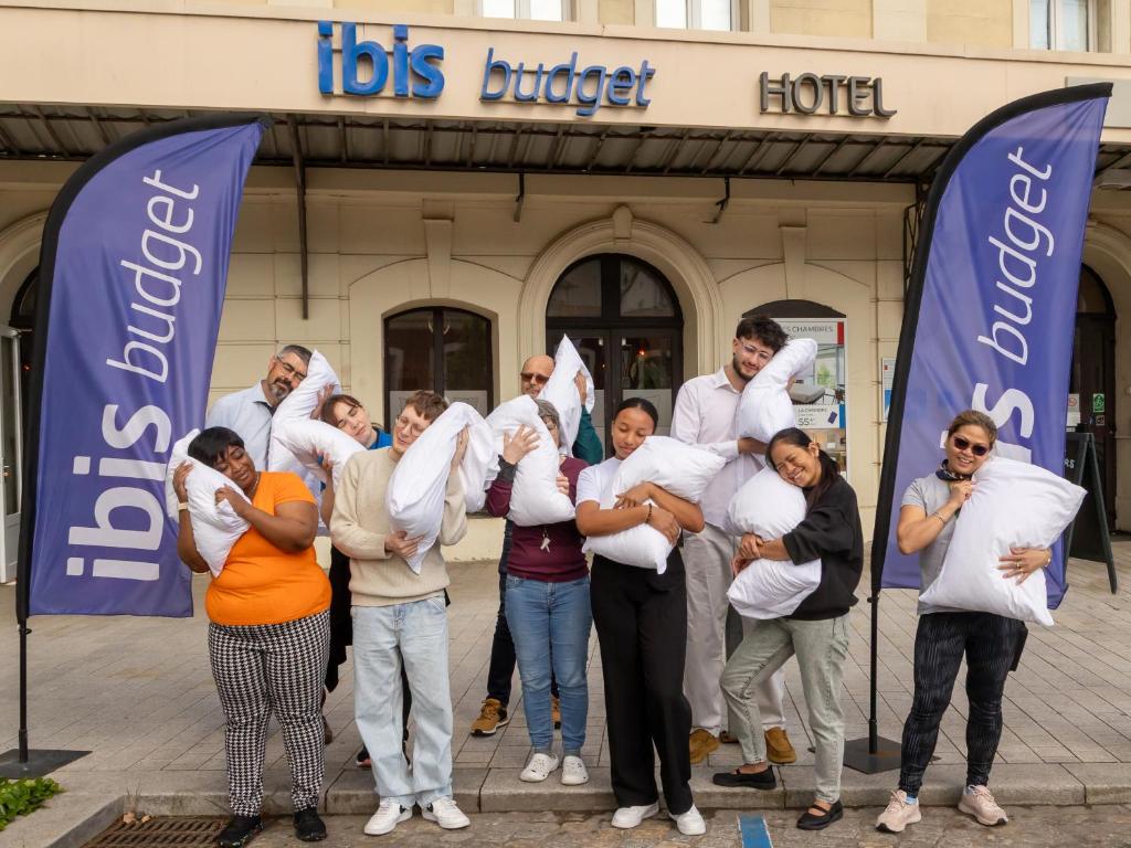 un groupe de personnes tenant des bébés devant un magasin dans l'établissement ibis budget Le Puy En Velay, au Puy-en-Velay