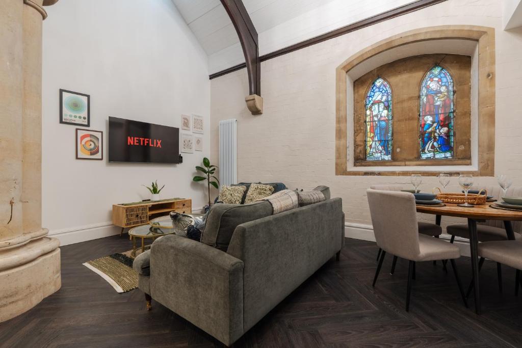 a living room with a couch and a table and a stained glass window at Rare Historic Church Stained Glass Parking in Waterloo