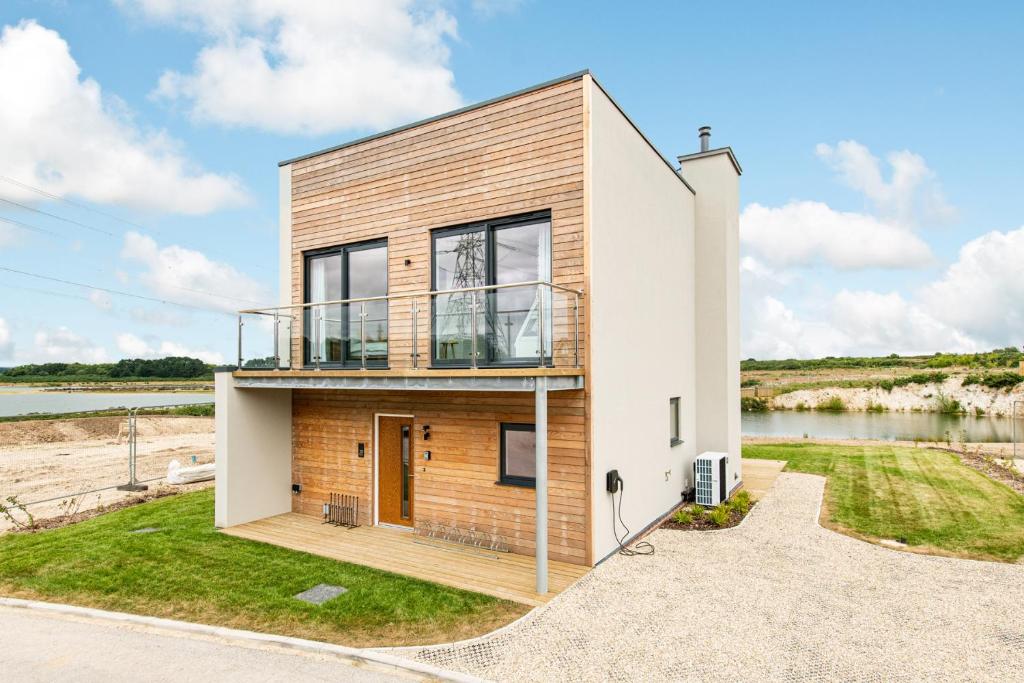 ein Haus am Ufer eines Flusses in der Unterkunft Songbird SV30 Silverlake Dorset in Warmwell