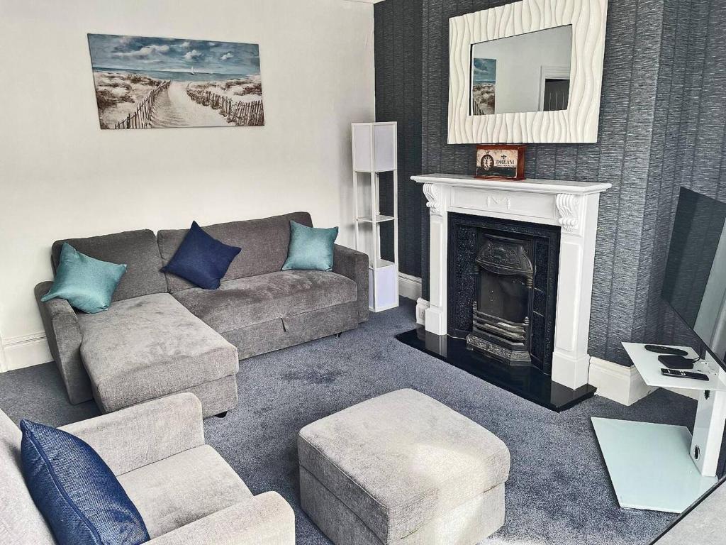 Una sala de estar con un sofá y una chimenea. en 2BR Filey Flat, Near Seafront - Perfect for Getaways, en Filey