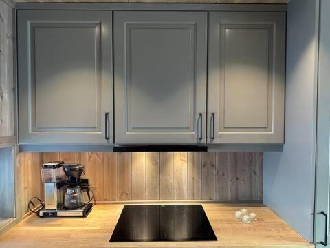 una cucina con mobili bianchi e un piano di lavoro nero di Aurdalsåsen panorama ad Aurdal