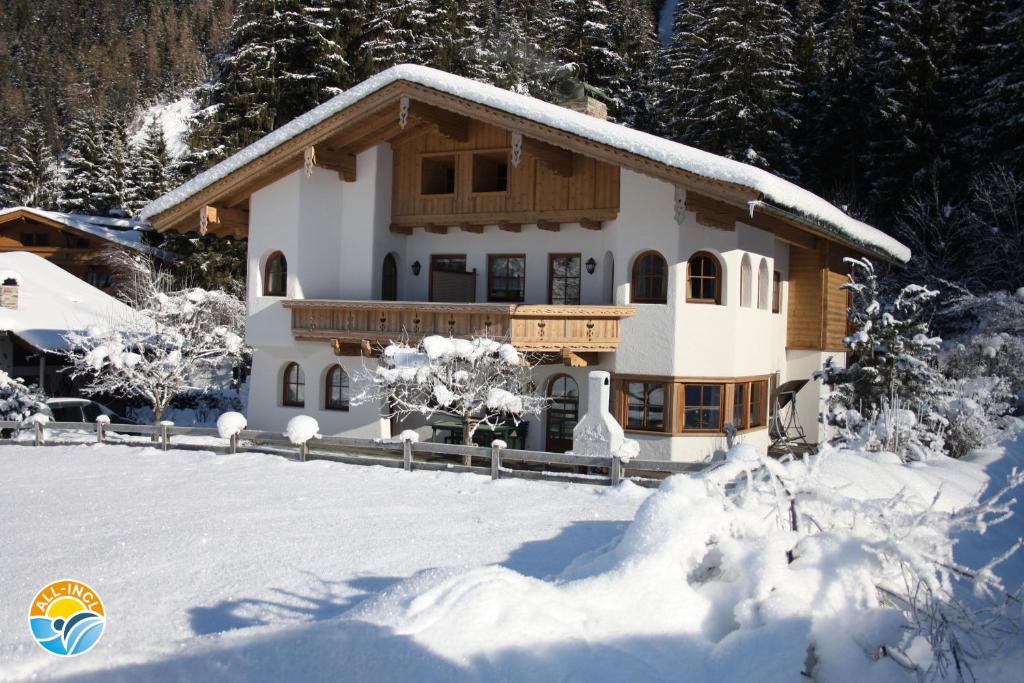 a house covered in snow in front at Vronis Waldhaus ADULTS ONLY in Mayrhofen