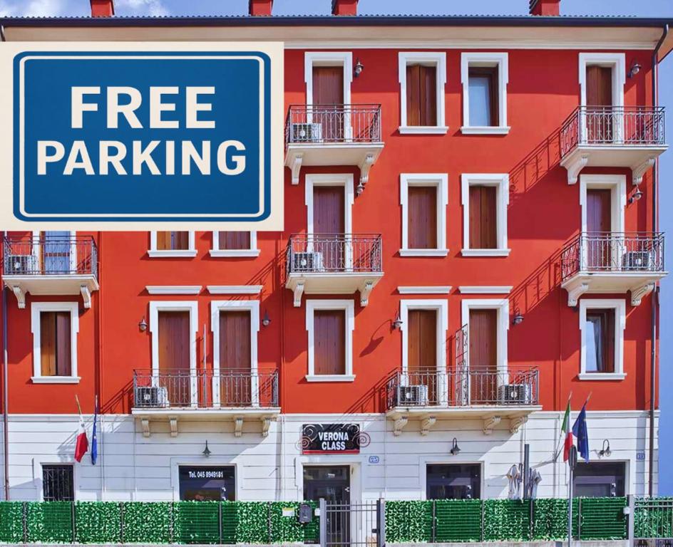 znak informujący o bezpłatnym parkingu przed czerwonym budynkiem w obiekcie Verona Class ApartHotel "Residenze del Cuore" w Weronie