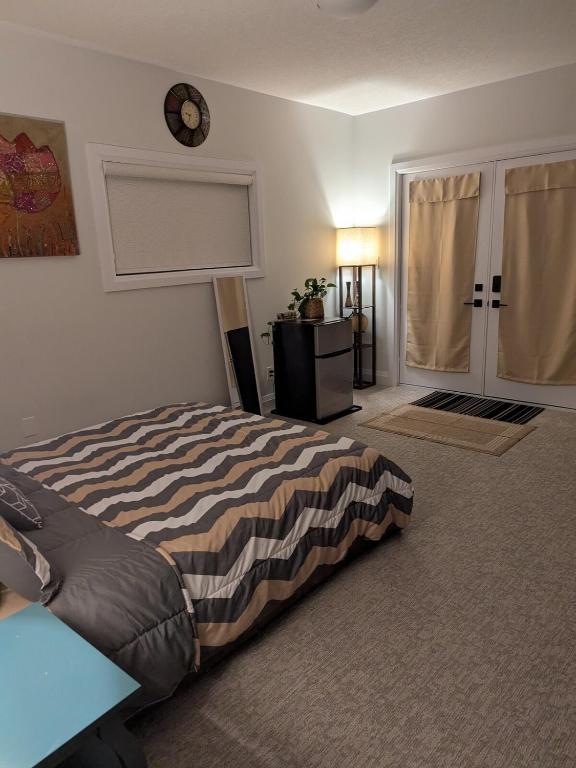 a bedroom with a bed and a clock on the wall at Spacious Luxury walk out Basement in Kitchener