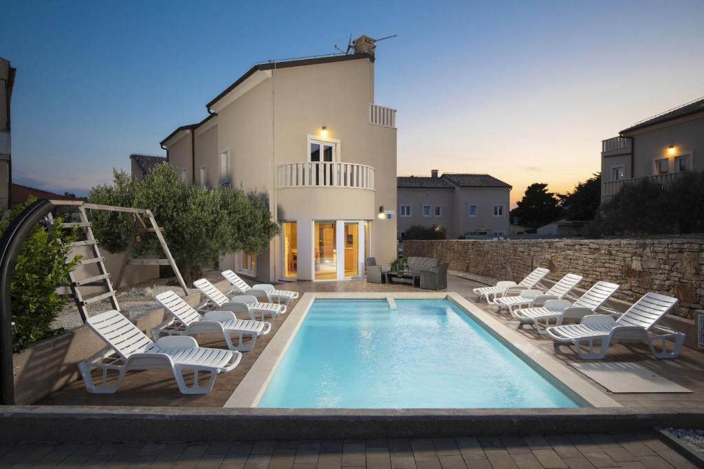 basen z leżakami obok budynku w obiekcie 6-bedroom Villa Chiara with Sea View w mieście Premantura