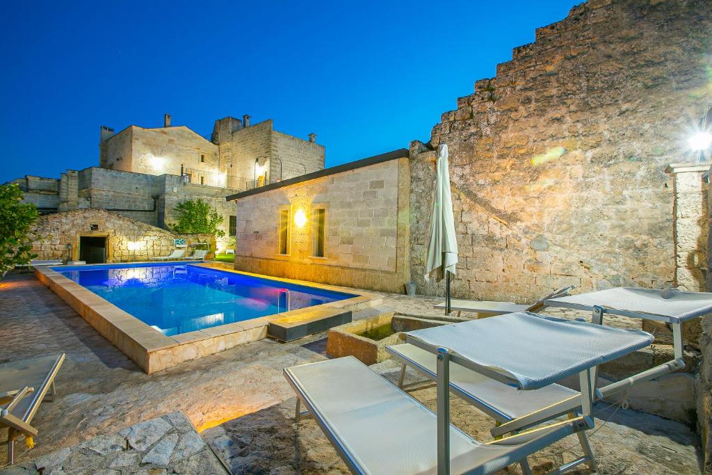 a villa with a swimming pool in front of a castle at Masseria Antoglia Rooms in Villa Castelli