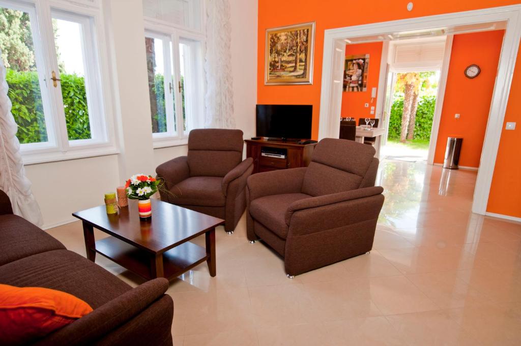 a living room with a couch and chairs and a table at Apartman Isadora in Opatija