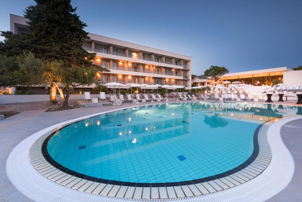 a large swimming pool in front of a hotel at Pharos Hvar Hotel in Hvar