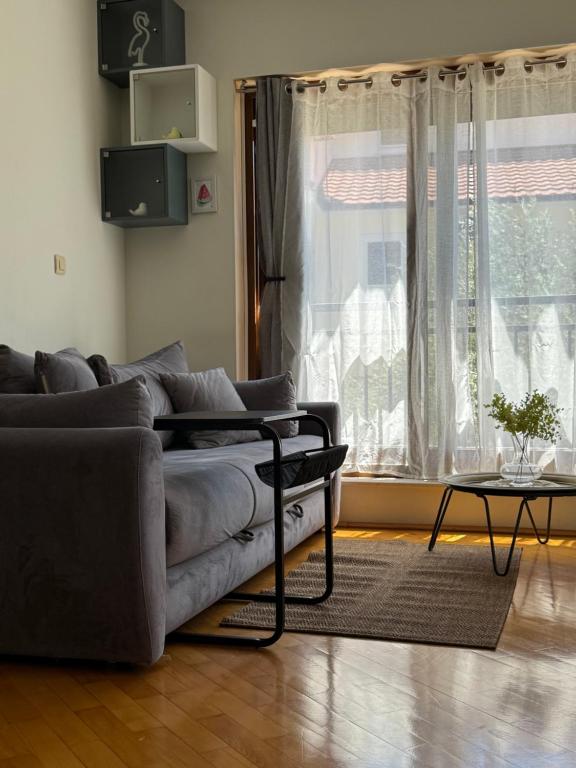 a living room with a couch and a table and a window at Emerald hills apartment in Baošići