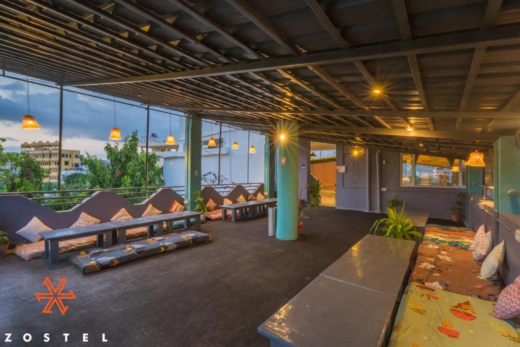 Un vestíbulo de un edificio con sofás y mesas. en Zostel Pushkar, en Pushkar