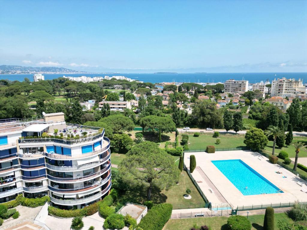 - une vue aérienne sur un bâtiment et une piscine dans l'établissement Résidence avec piscine, Golf & plages à proximité - Palmazur Vacances, à Mandelieu-la-Napoule