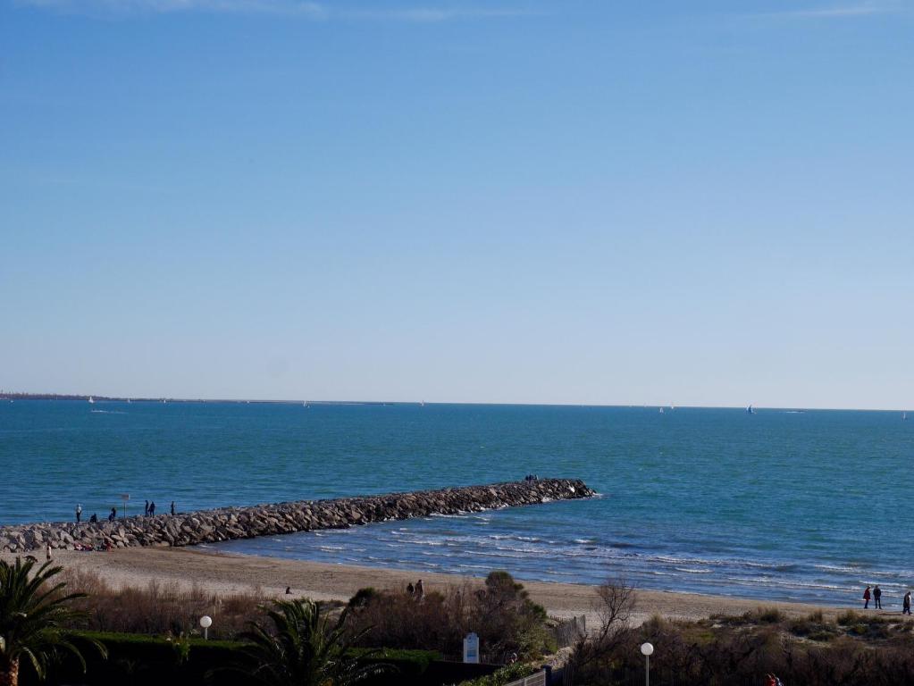 a group of people standing on a beach near the ocean at La Grande Motte by la Paillère in La Grande Motte