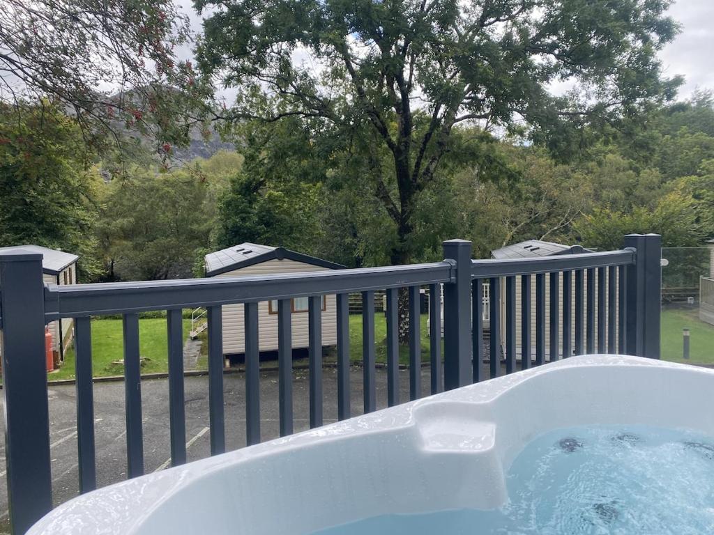 a hot tub on a porch with a fence at V29 - Rivers Retreat in Bethesda