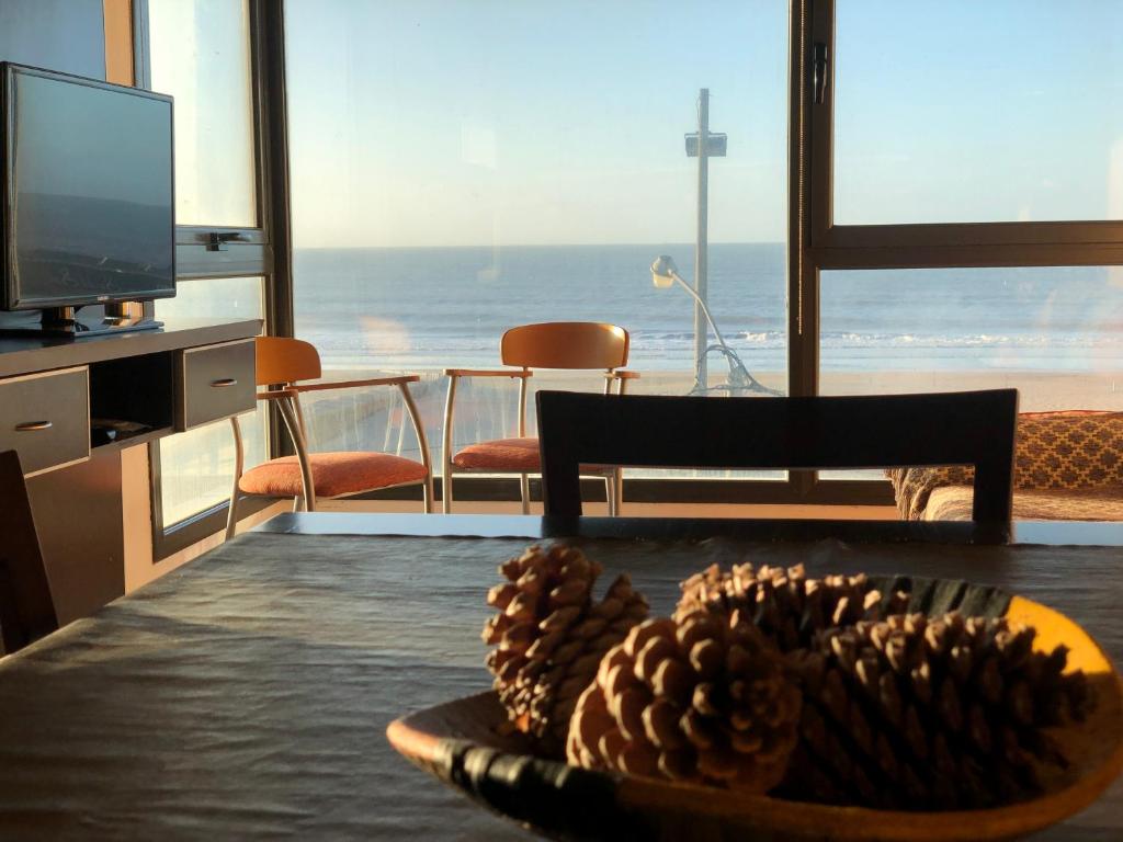 a living room with a table with a bowl of pine cones at Ventanas al Mar in Villa Gesell
