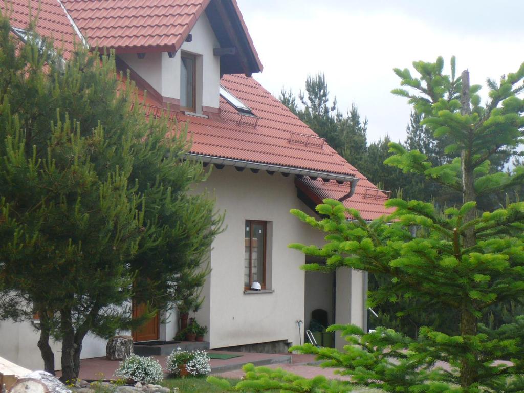 una casa con techo rojo y algunos árboles en Agroturystyka Sominy Piotr, en Sominy