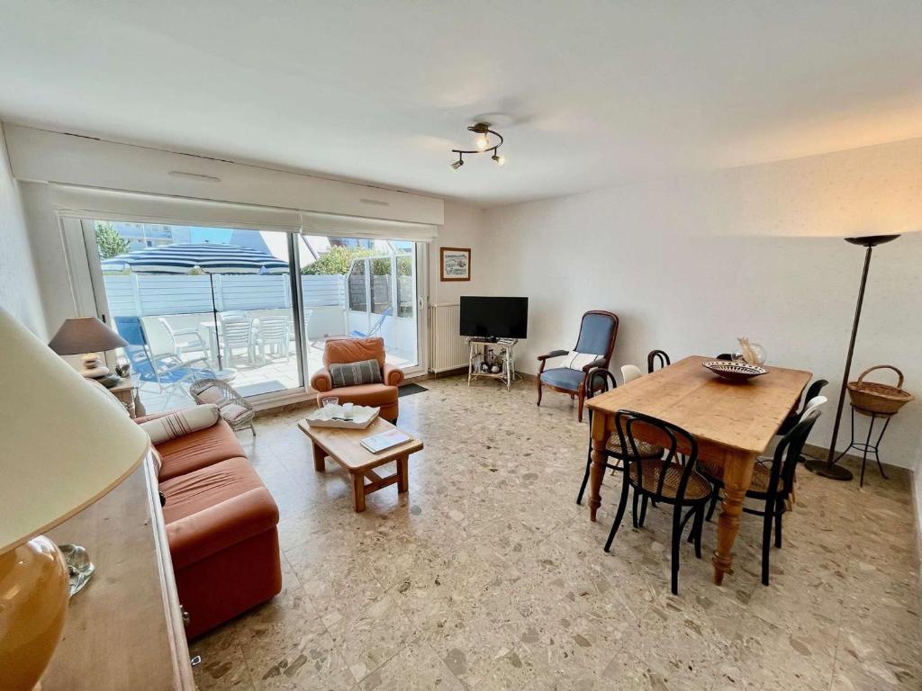 un salon avec un canapé, une table et des chaises dans l'établissement Quiberon - Appartement T3 de 65m² en rez-de-chaussée avec terrasse, proche plage et stationnement - FR-1-478-217, à Quiberon