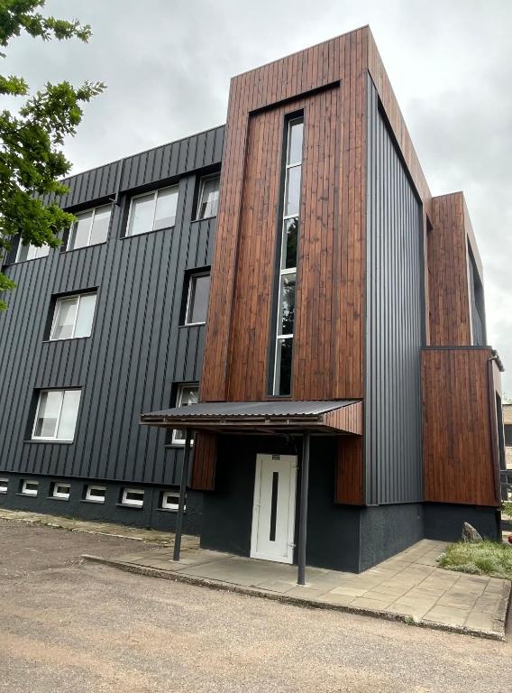 a building with a wooden facade with a white door at 1 kambario apartamentai in Raseiniai