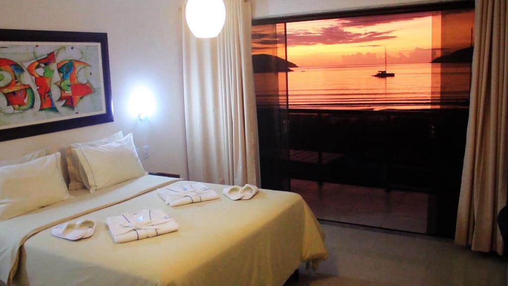 um quarto de hotel com uma cama com duas toalhas em Pousada Canto da Baleia em Arraial do Cabo