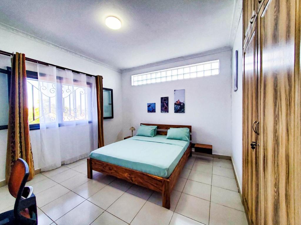 a bedroom with a bed and a window at Les Alizés appartement 4 in Toamasina